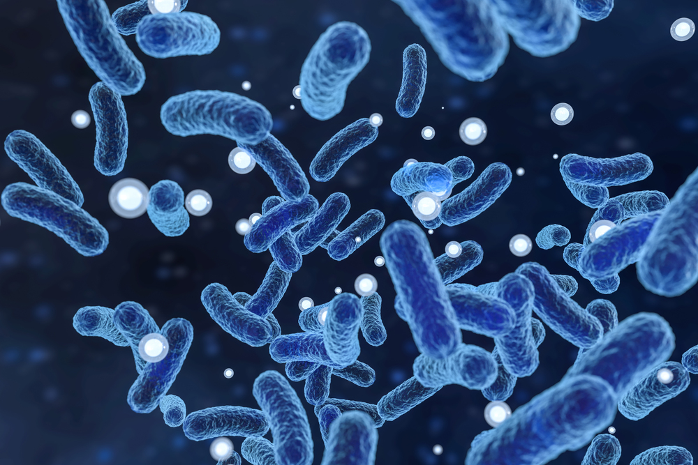 현미경으로 본 세균을 디지털로 표현한 것입니다. 푸른색의 막대 모양 세균들이 공중에 떠다니며, 주변에는 작은 공 모양의 입자들이 퍼져 있습니다. 이는 살모넬라균을 시각적으로 표현한 이미지로, 식중독이나 감염을 유발하는 박테리아를 나타냅니다. 배경은 어두운 색조로 되어 있어 세균들이 더욱 도드라져 보입니다.
