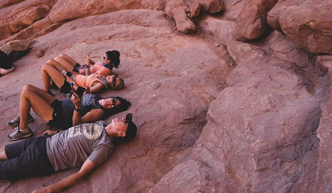 출처: Unsplash 제공, 등산 중 큰 바위에 누워있는 등산객들 사진