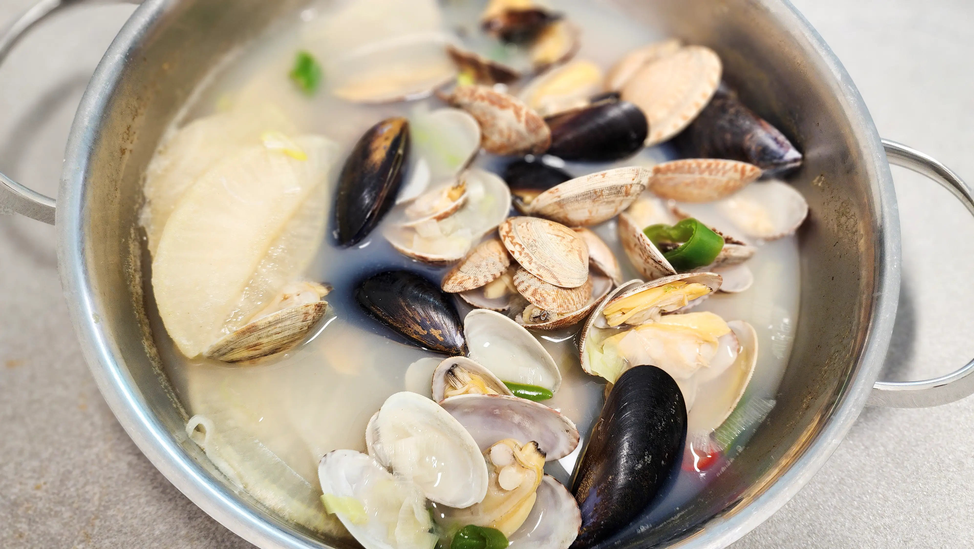 홍합과-바지락과-국물이-들어-있는-넓은냄비가-식탁위에-있는- 사진-02