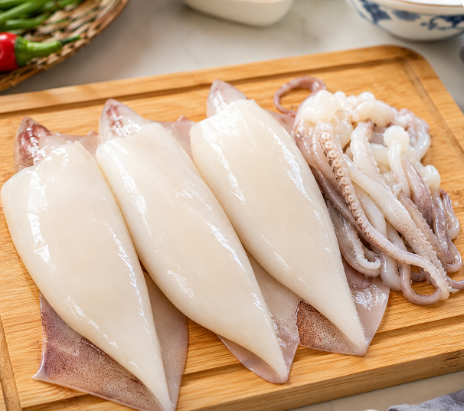 도마 위에서 싱싱하고 탱글탱글한 오징어가 깔끔하게 손질되어 나열된 모습