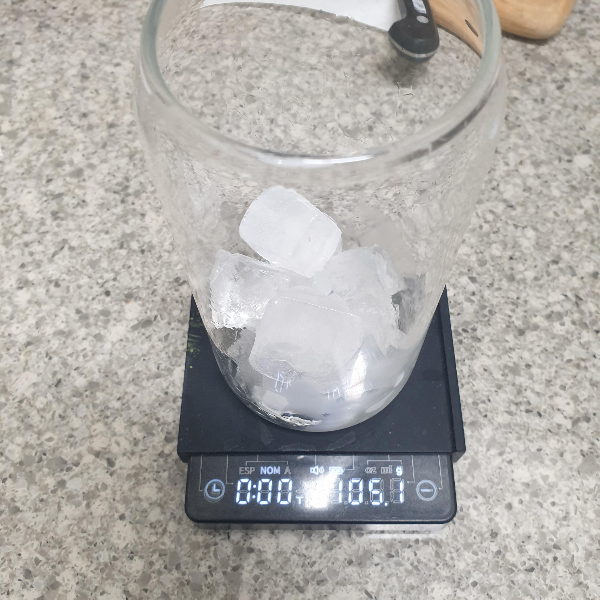 저울위에 얼음 100g이 든 유리컵이 올려져있다.