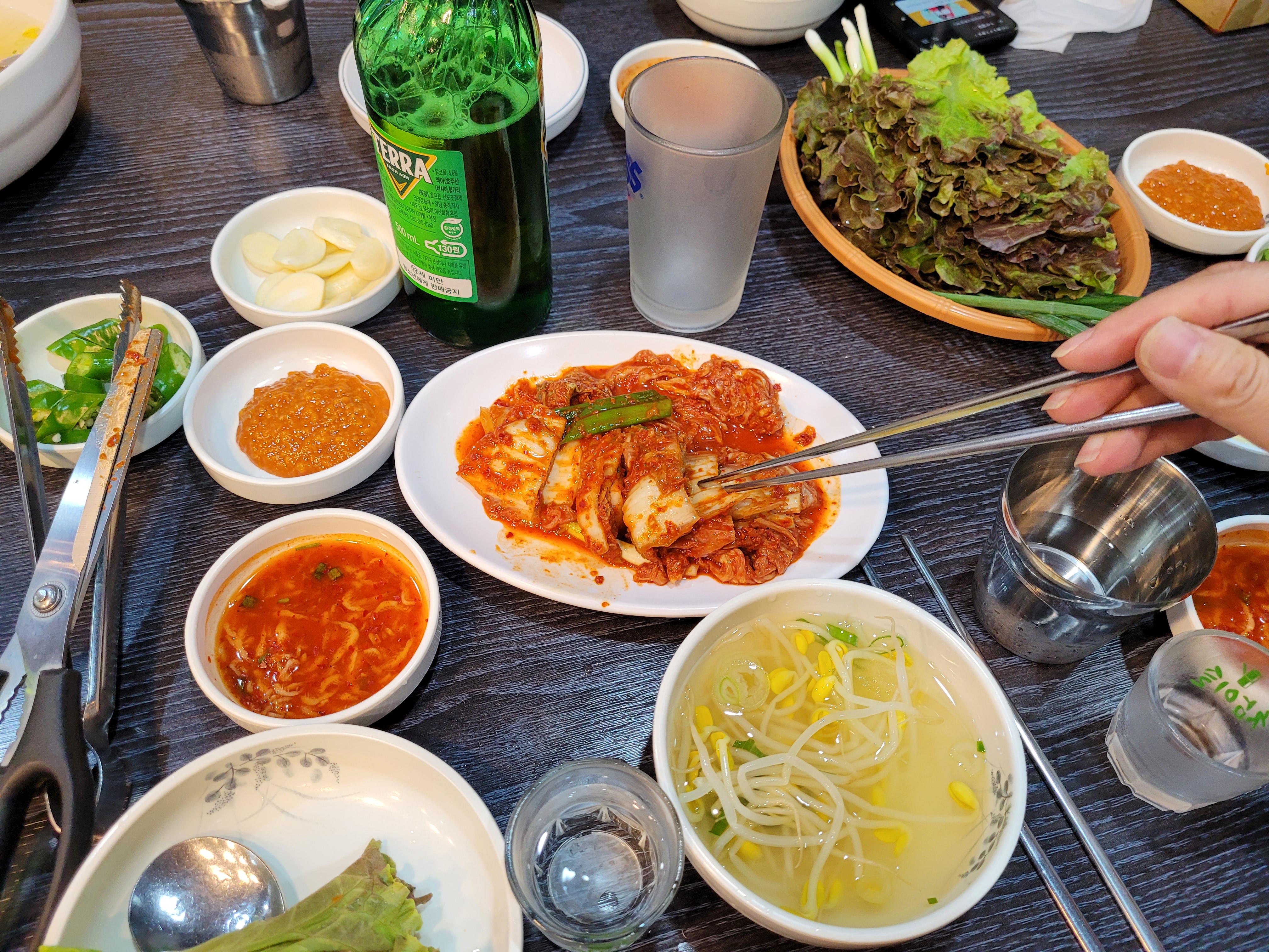 기본 반찬에서 김치를 젓가락으로 집어 먹고 있음