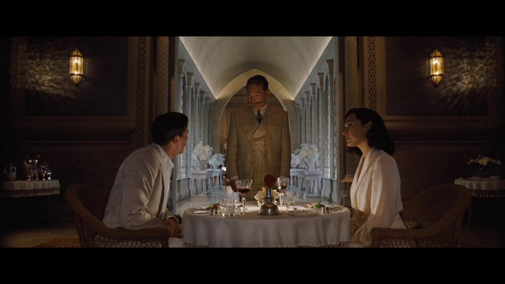 영화 나일 강의 죽음 스틸컷 - 신혼 부부와 포와로 탐정이 식사 중 대화하는 장면