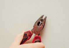 펜치로 나사 머리를 돌리고 있는 사진