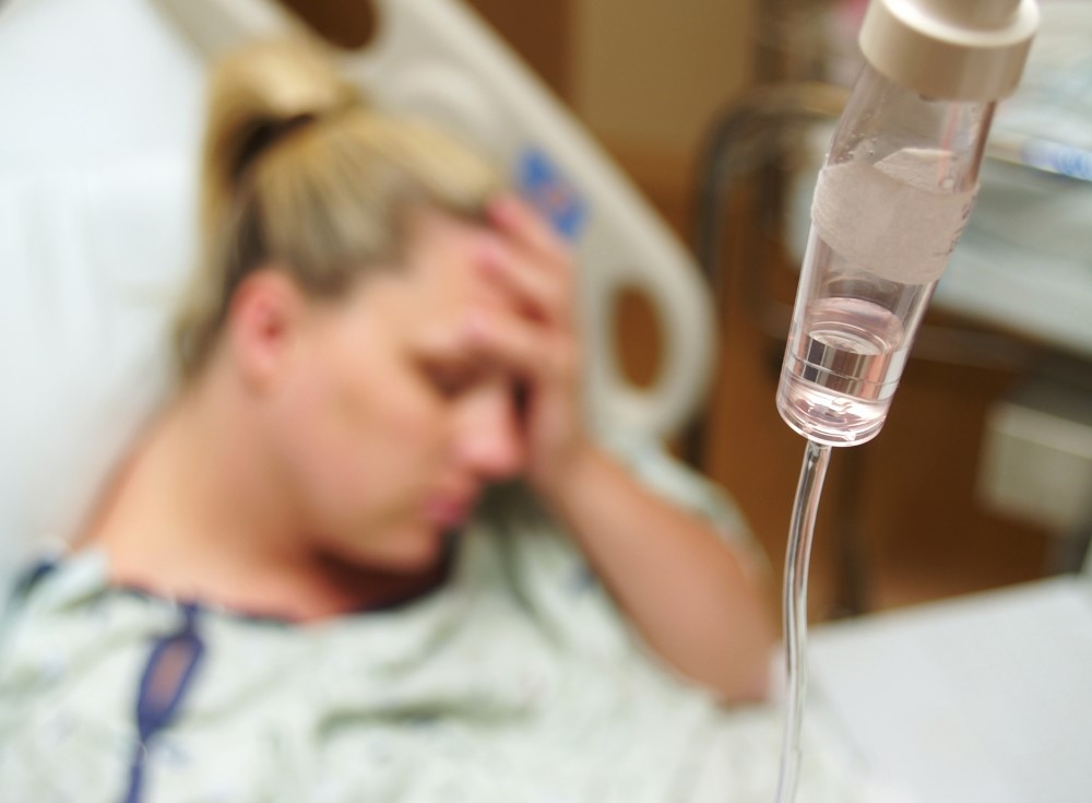 병원 침대에 누워있는 환자와 수액 링거, 건강 악화로 인한 입원 치료를 받고 있는 상황 via canva