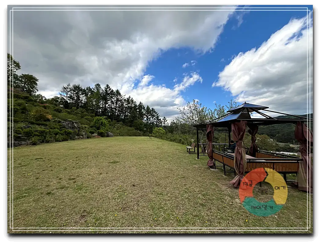 어흘_잔듸광장-야외테이블-지붕-흰구름-파란하늘