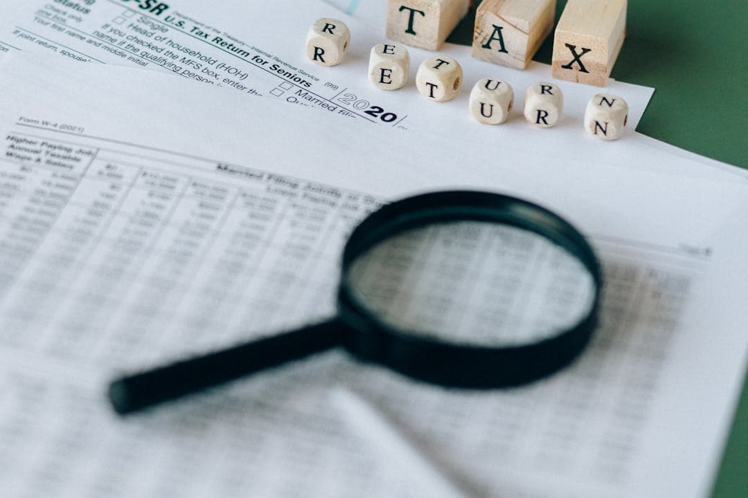 세금 서류를 돋보기로 자세히 보고 있는사진