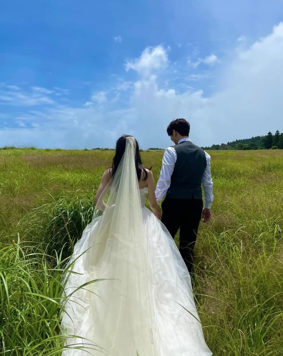 웨딩드레스 차림의 김연아, 가벼운 수트 차림의 고우림의 뒷모습