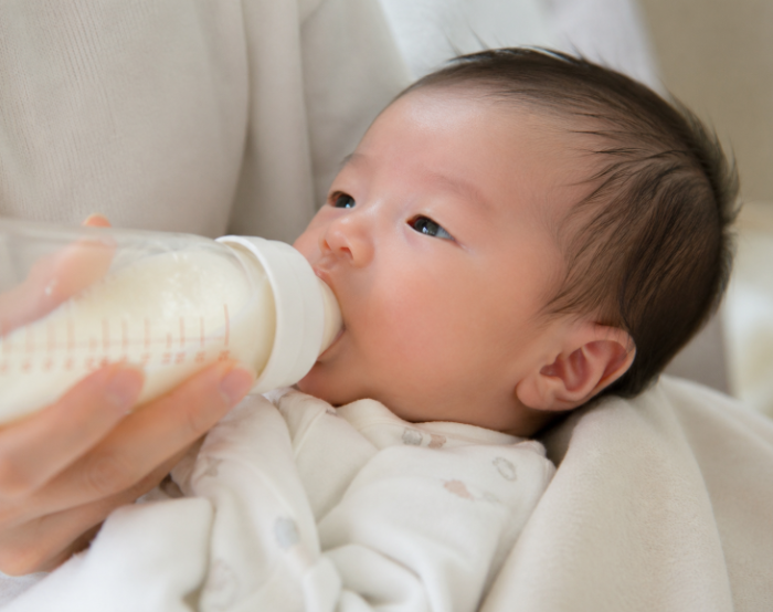 신생아 분유 수유 모습, 아기에게 젖병으로 우유를 먹이는 육아 초기 장면