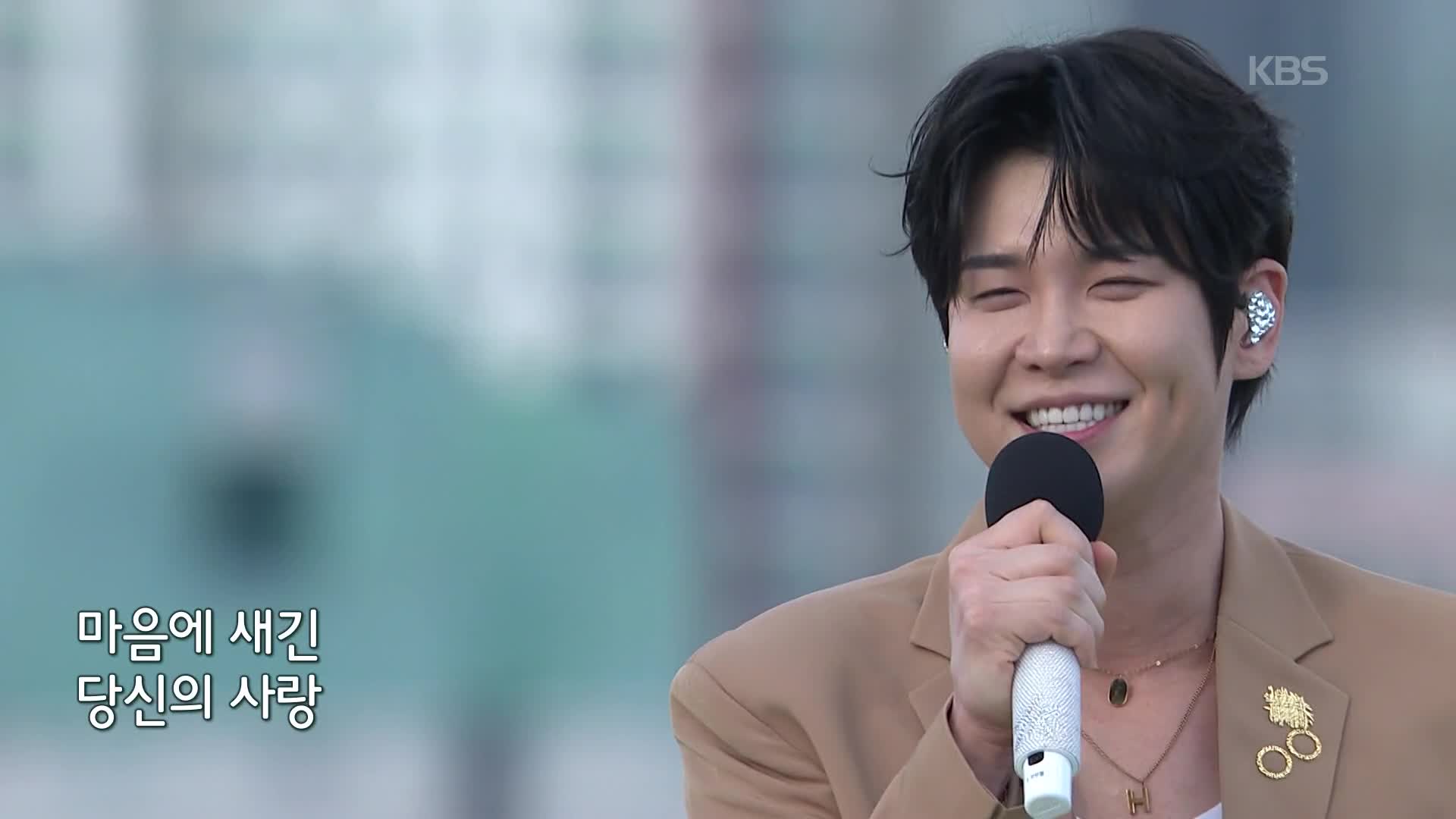 갈색 재킷을 입고 마이크를 든 장한별의 방송 장면