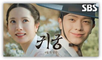 남너 주인공이 등을 서로 맞댄 채 화면 정면을 보며 서로 미소 짓고 있다.