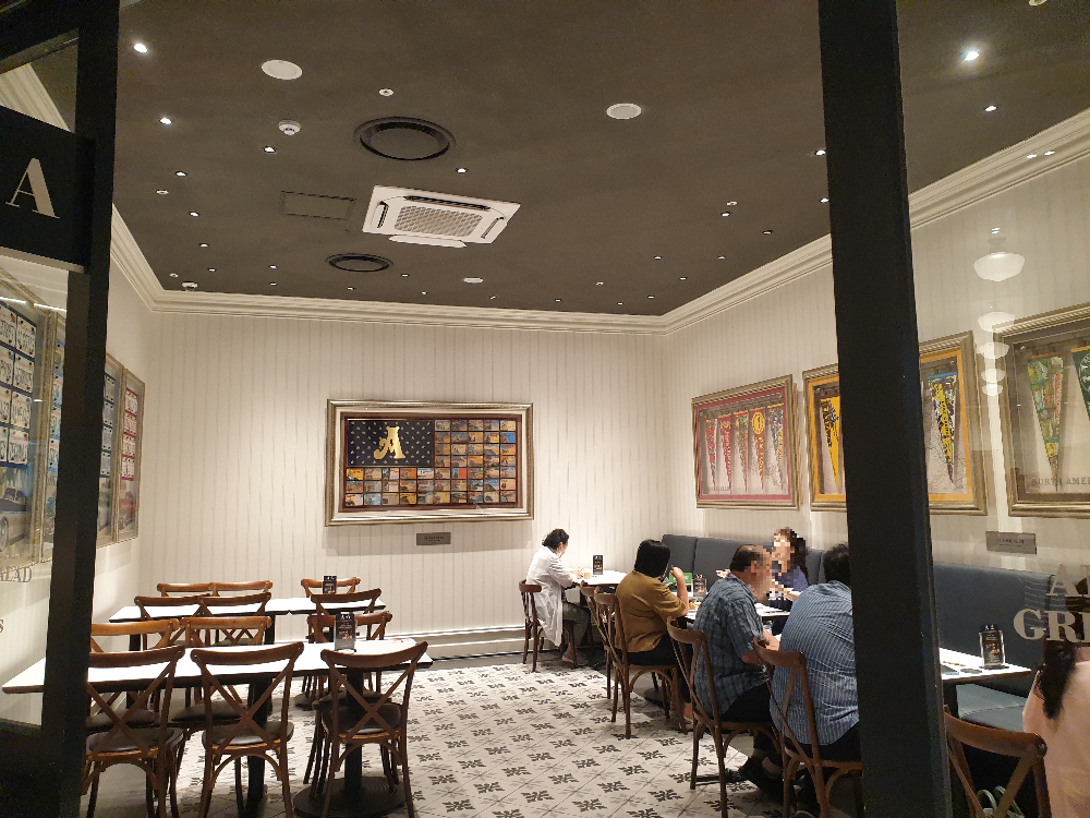 좌석 테이블간 거리와 통로가 넉넉한 모습, 한쪽는 5팀이 있고 반대편 테이블에는 사람이 없다.