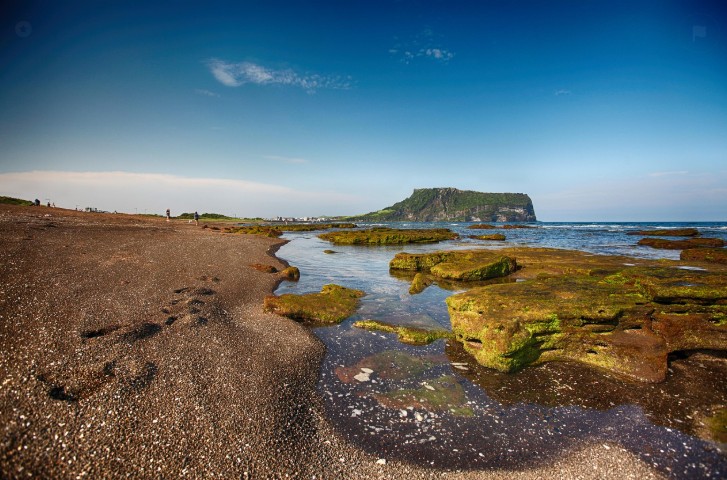 바닷가에서 성산일출봉을 배경으로 찍은 이미지