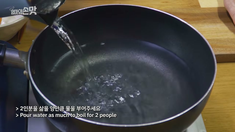 냄비에 물을 붓는 장면