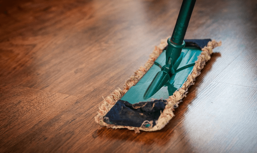 대 걸레로 마루 청소를 하고 있다