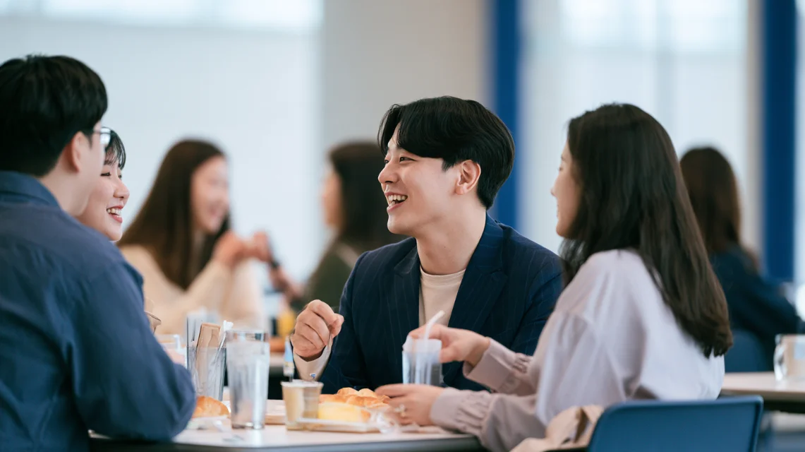 회사 구내식당에서 동료들과 점심을 먹는 신입 사원