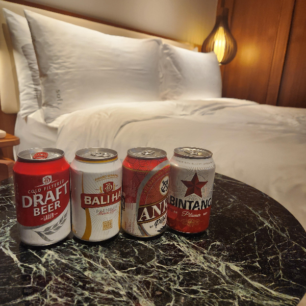 침대 앞에 맥주 4종이 테이블 위에 놓여있다.