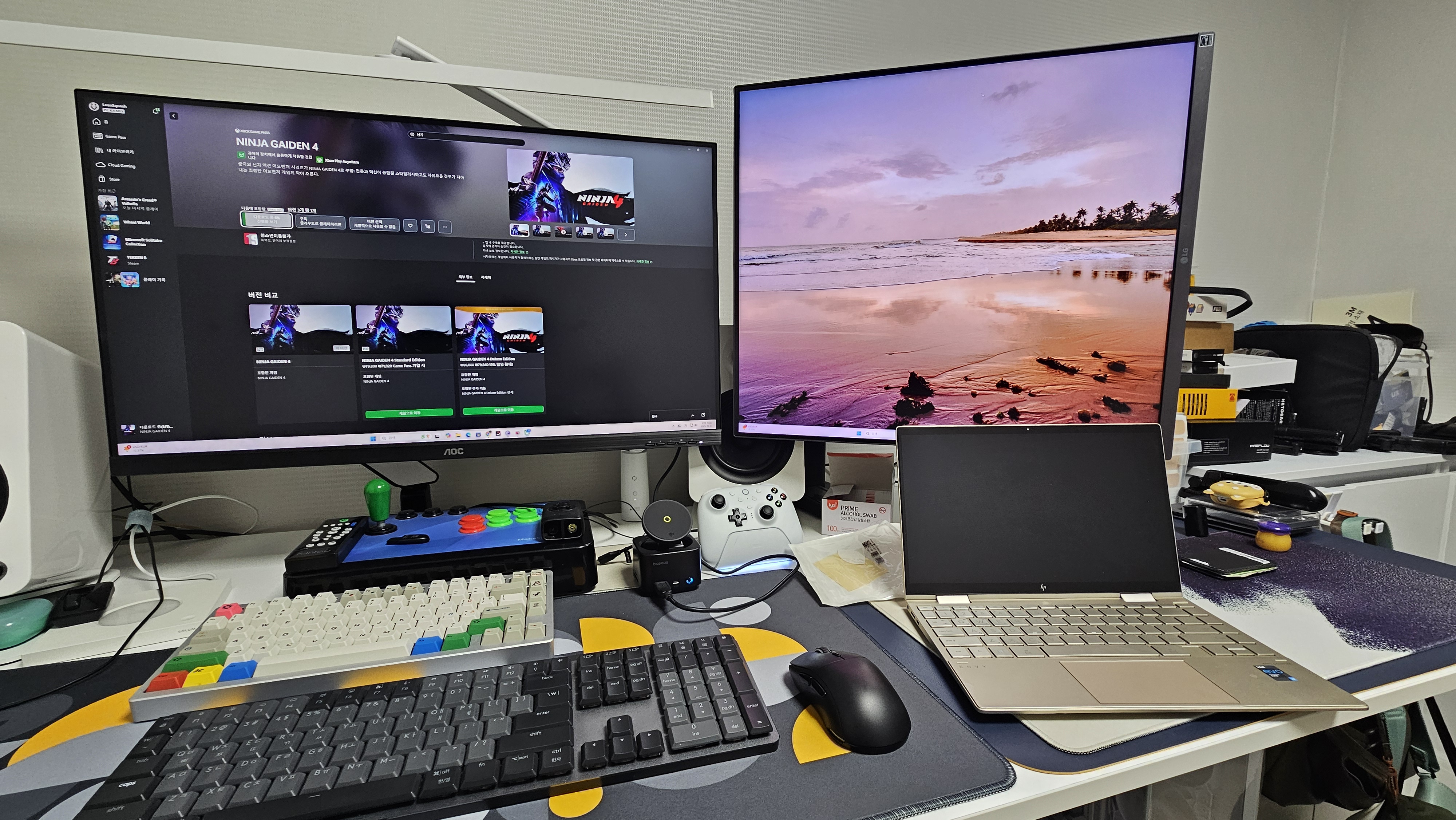 책상 위에 나란히 놓인 두 대의 모니터와 키보드·마우스가 놓여 있고, 한쪽에는 작업 창이, 다른 쪽에는 참고 자료와 영상이 함께 띄워진 듀얼모니터 작업 환경 모습