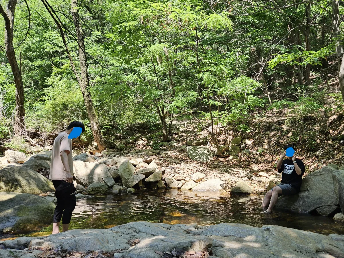 계곡에-발을-담군-채-놀고-있는-두-남성