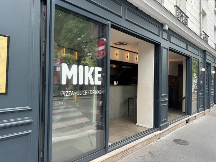 The dark grey modern facade of MIKE pizza shop near Canal Saint-Martin in Paris
