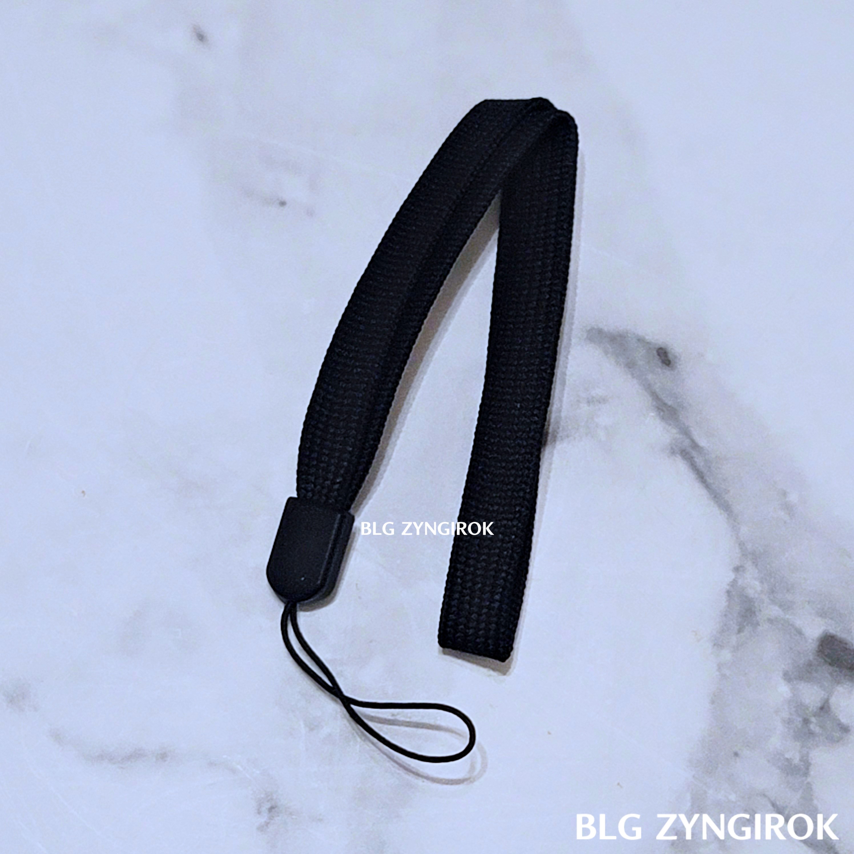 알리익스프레스에서 구매한 블루투스 리모컨에 걸 스트랩이 테이블 위에 놓여있다.