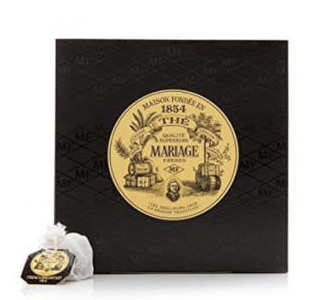 사각 박스에 황금색 원이 있고 그그 원ㅇ네 1854와 브랜드 이름이 적혀있는 오래된 로고가 보인다. 티백하나가 앞에 있다.