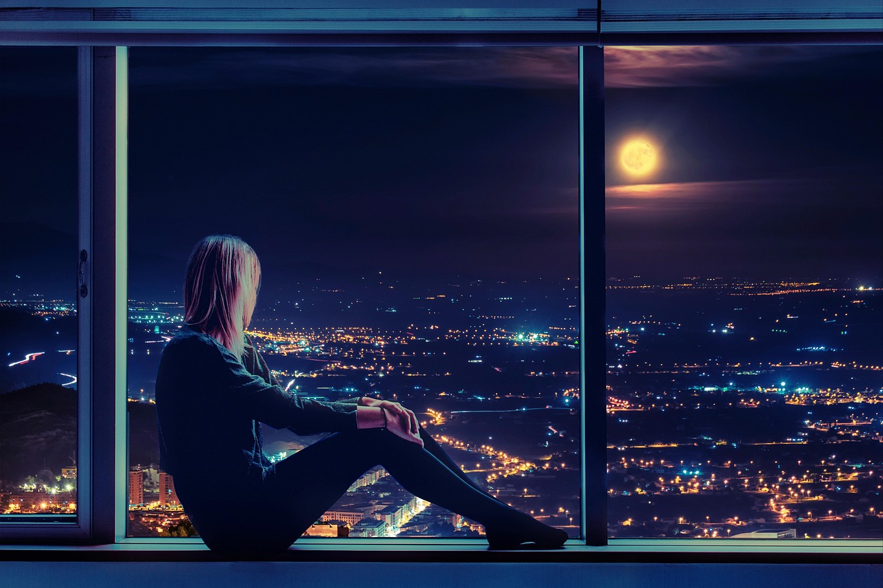 창가에 앉아 야경을 보고 있는 사람