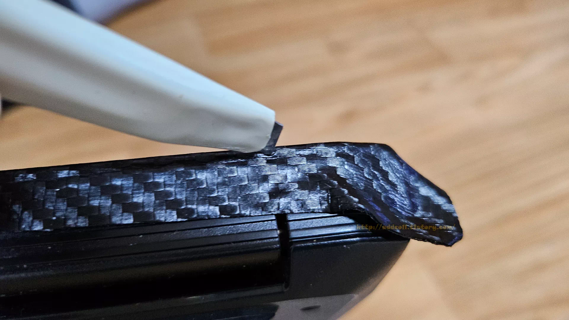 붙이고 조금 남는 시트지를 칼로 자르는 모습