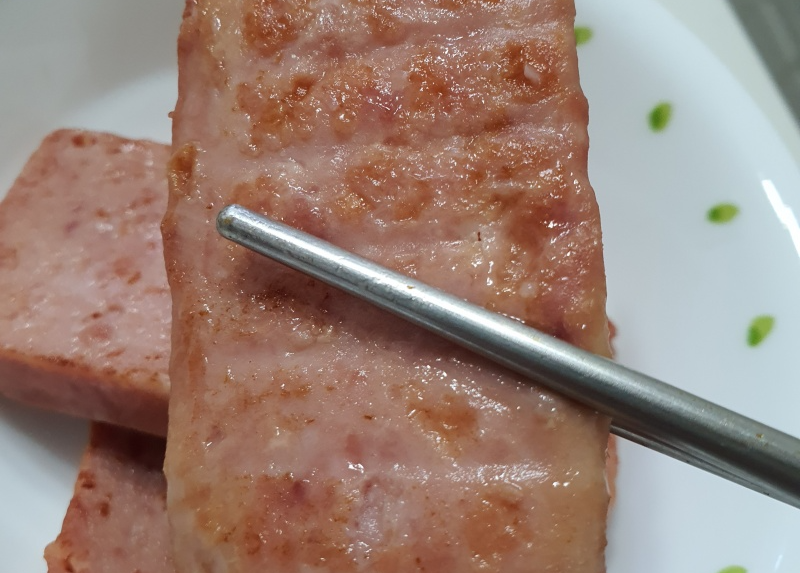 젓가락으로-집어든-스팸-한조각