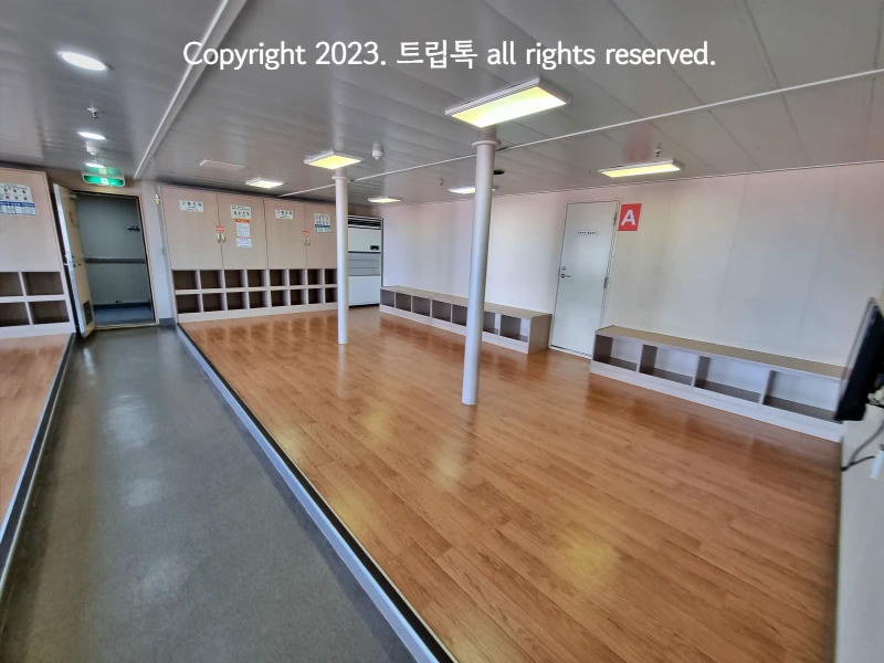 넓은 객식의 모습. 마루로 이루어져 있고 사물함과 에어컨이 보인다.