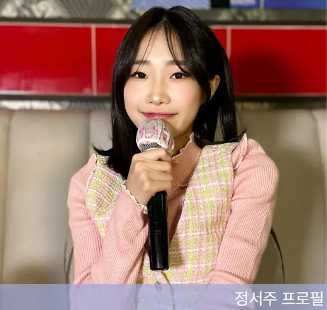 가수 정서주가 마이크를 들고 있는 사진, 분홍색 상의