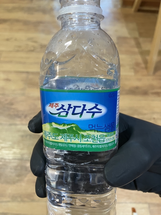 사포질 작업을 위한 물 준비용 생수병을 손에 든 사진