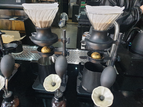 하리오 스위치와 뉴클리어스 파라곤 칠링 드립 스탠드 2 세트가 보인다. 주문한 커피를 추출 중이다.