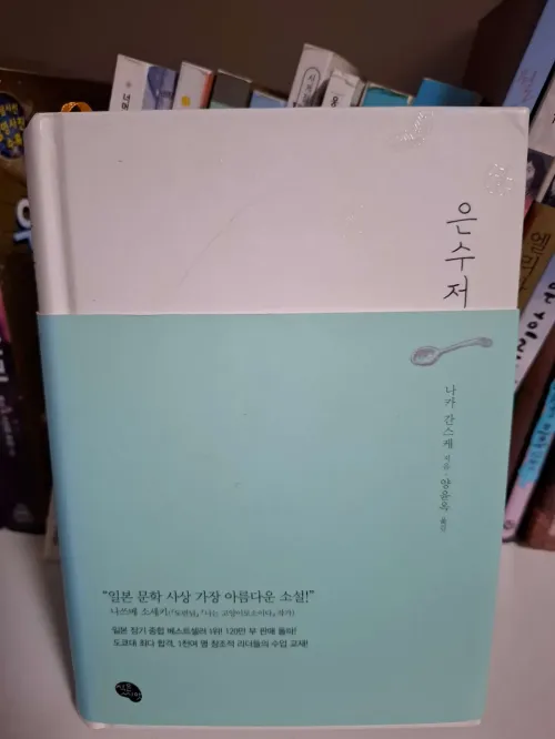 낡은 다락방의 희미한 빛 아래 놓인 은수저를 보며 자신의 뿌리와 자립의 의지를 다지는 고독하지만 강인한 관찰자의 시선(The eyes of a lonely but strong observer who firms his will for independence while looking at a silver spoon placed under the faint light of an old attic)