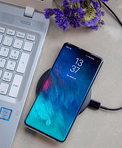 노트북 옆에 스마트폰이 있다. 파란 화면을 가진 스마트폰으로 보호필름을 부착했다.