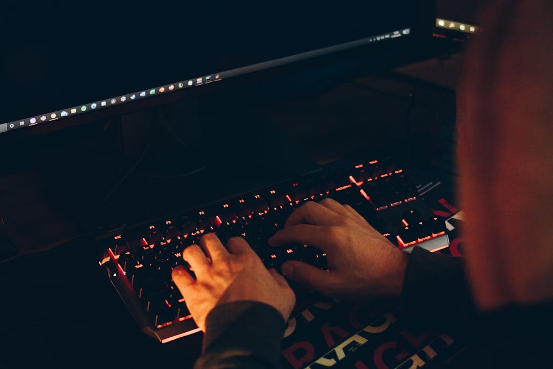 어두운 방에서 키보드를 타이핑하는 손 – 해커의 유심 탈취 위협