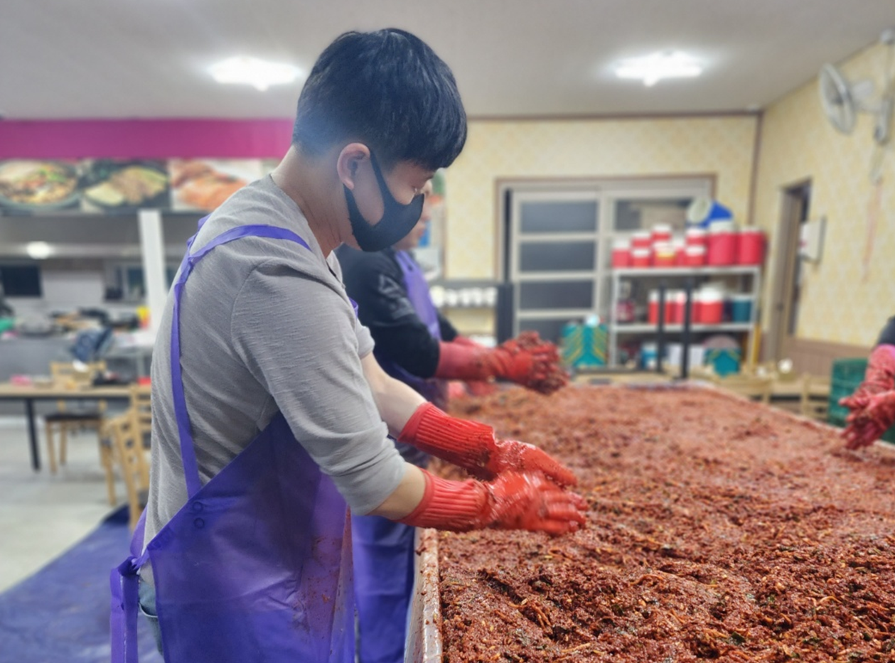 신랑이 김치 양념을 버무리고 있다.