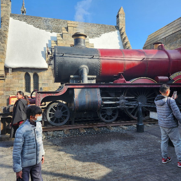 붉은색 기차모형이 놓여 있다. 사진 찍기 바쁜 사람들