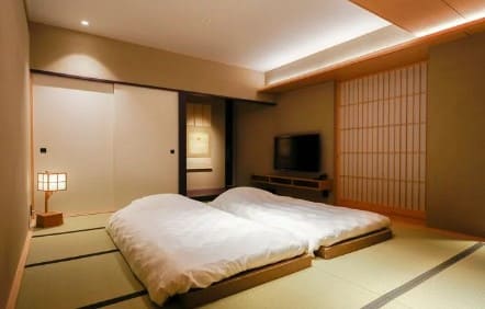 타다미 위에 높이가 낮은 침대가 2개 놓여져 있다.