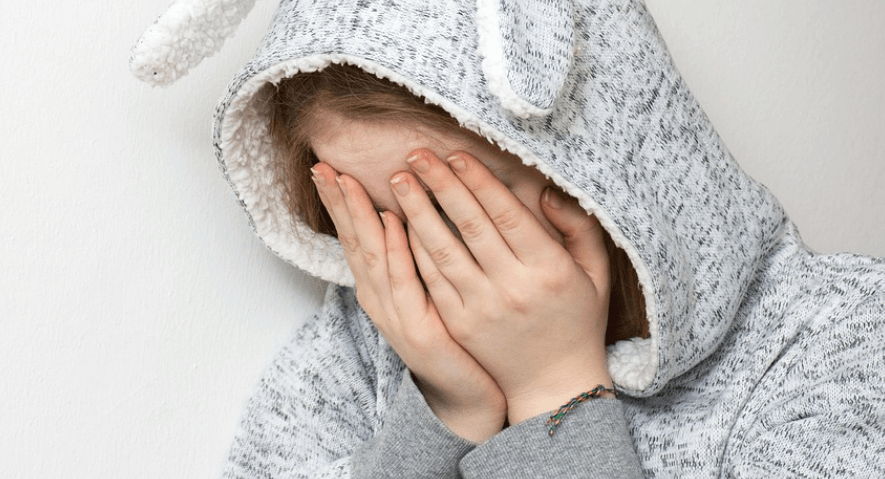 손으로 얼굴을 가리며 울고 있는 여성