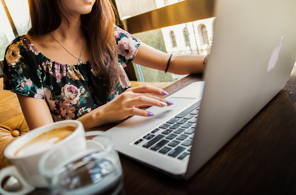 여성이 노트북을 켜고 책상에서 업무를 보고 있다.