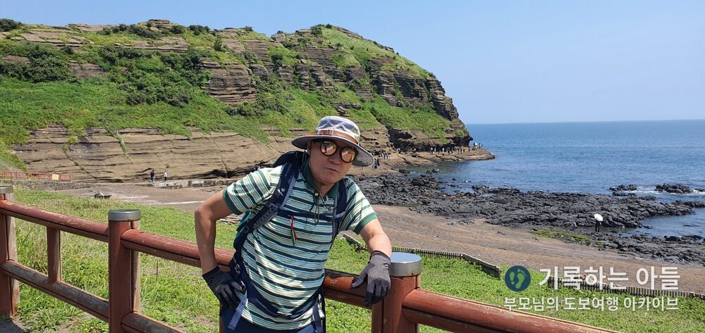 용머리해안 층리 절벽을 배경으로 선 아버지