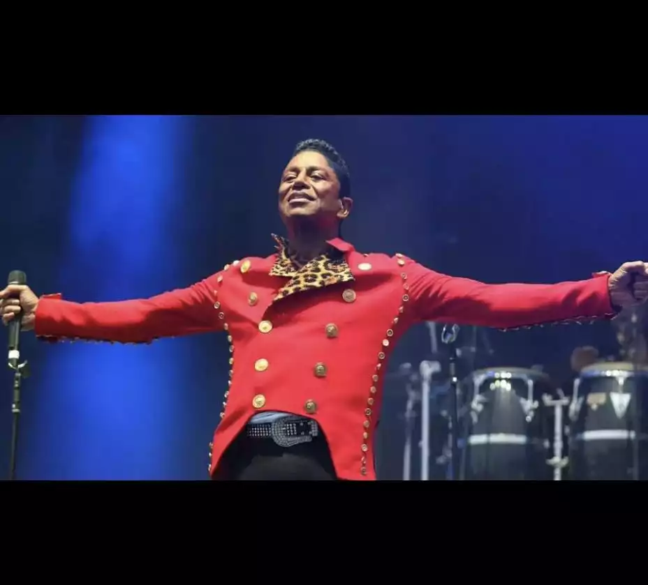 이제는 원곡 저메인 잭슨이 무대에서 빨간 복장을 입고 팔을 벌린 상태