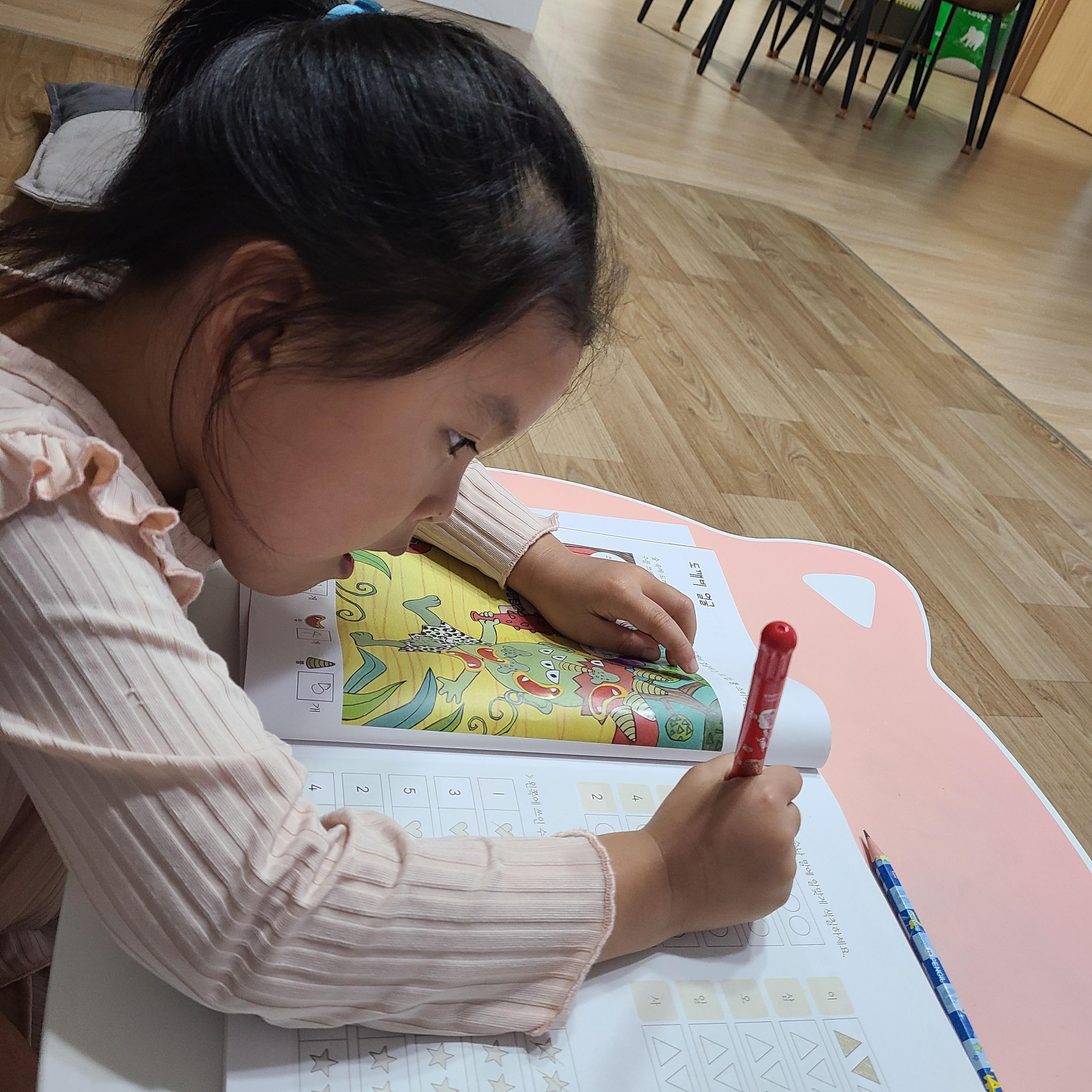 초등 1학년 아이가 집에서 학습지를 스스로 풀며 집중하는 모습, 자기주도 학습 습관 기르기.