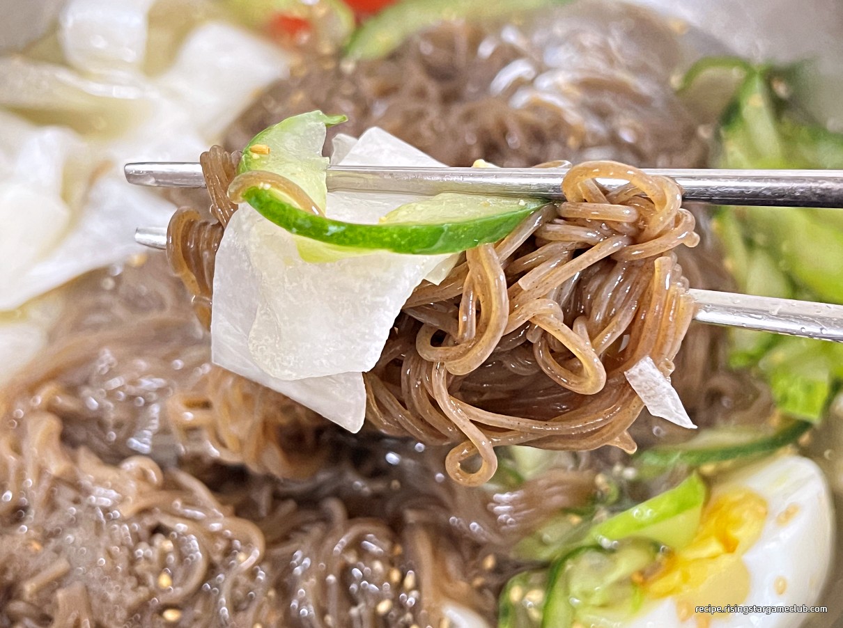 냉면 면과 고명을 한젓가락 집은 사진
