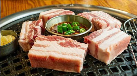 삼겹살이 불판 위에 올려진 모습