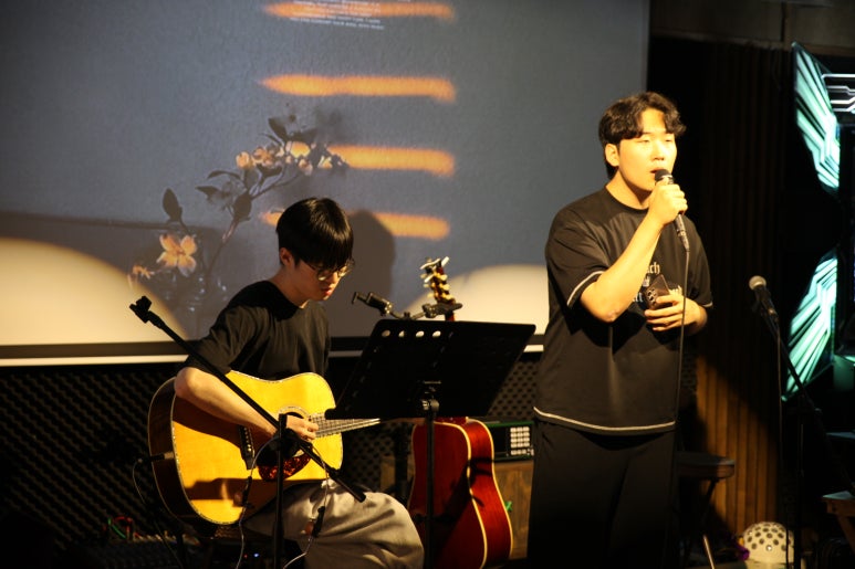 통기타 반주에 맞춰 마이크로 노래하는 소리샘 참가자