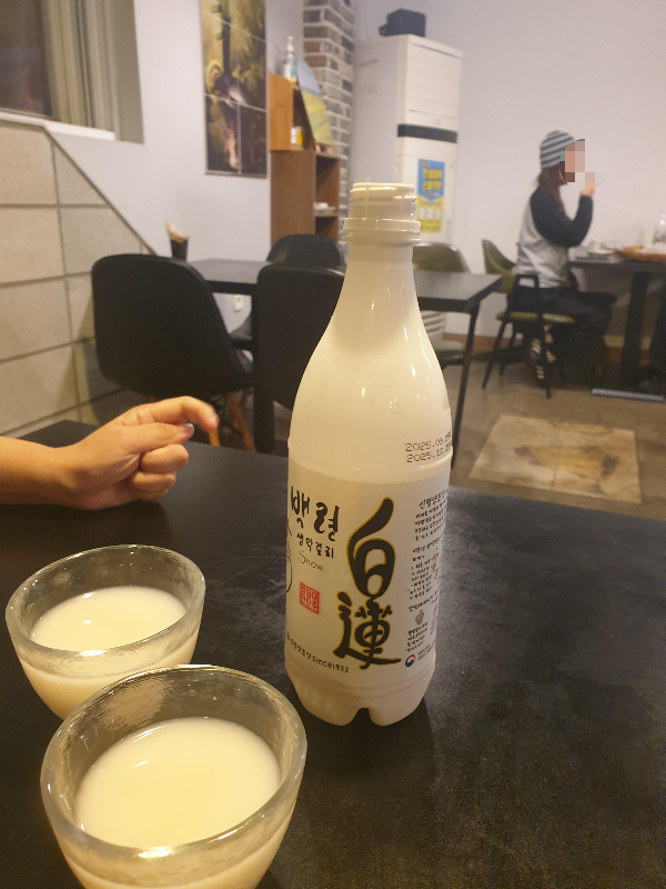 막걸리 병과 술 잔 2개가 테이블에 올려져 있다.