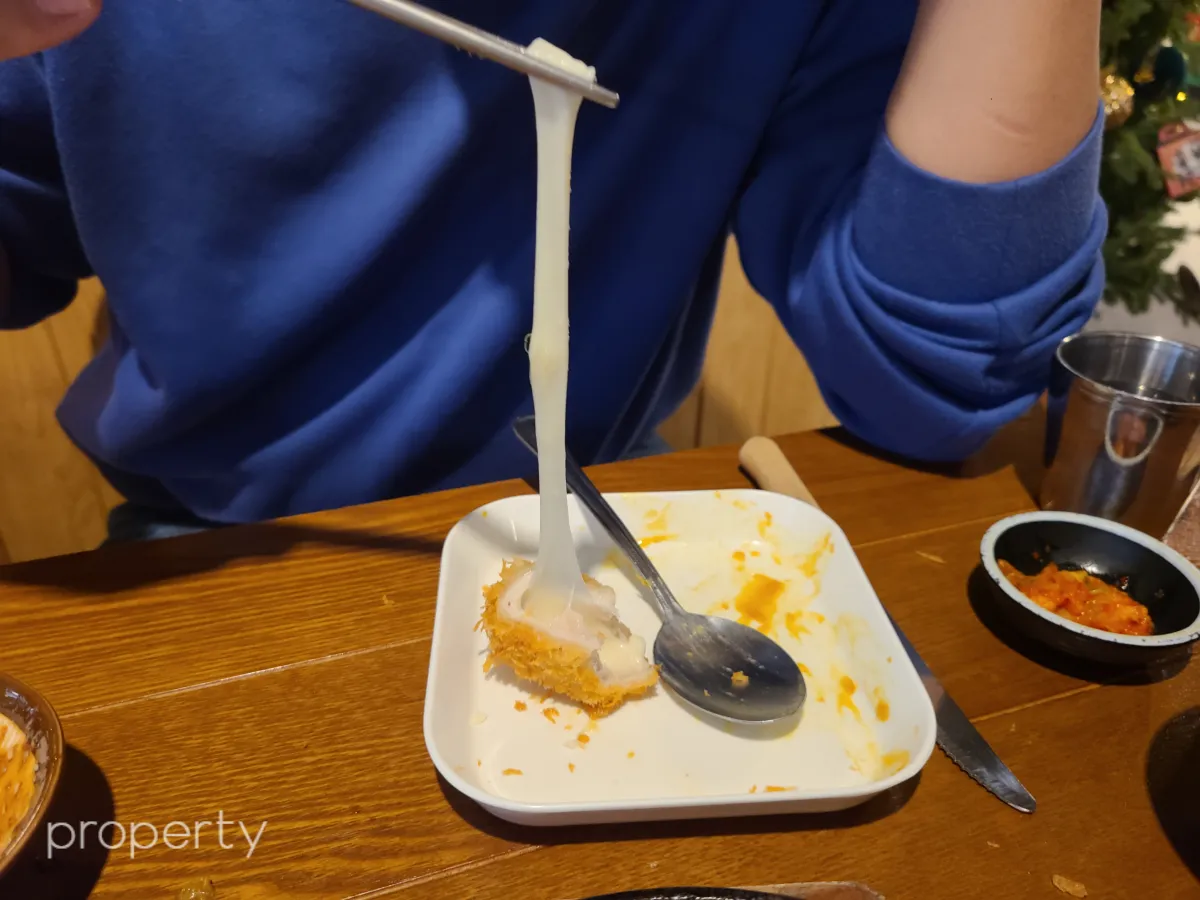 파란색옷을입은남자-치즈돈가스치즈를-길게늘어뜨린모습