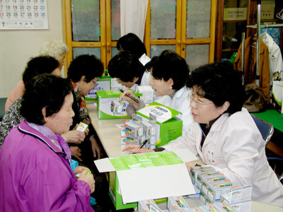 약사들이 노인들에게 약처방을 설명하고 있는 모습